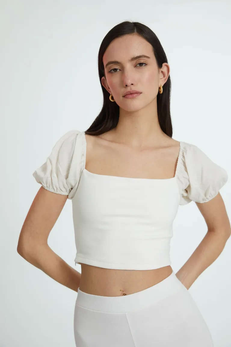 Top blanco confeccionado en tela de punto con mangas abullonadas y diseño moderno de Naíma en Tops para argentina