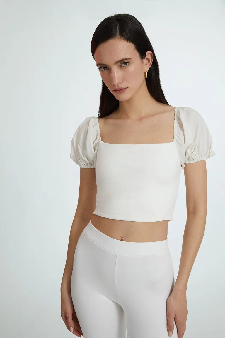 Top blanco confeccionado en tela de punto con mangas abullonadas y diseño moderno de Naíma en Tops para argentina
