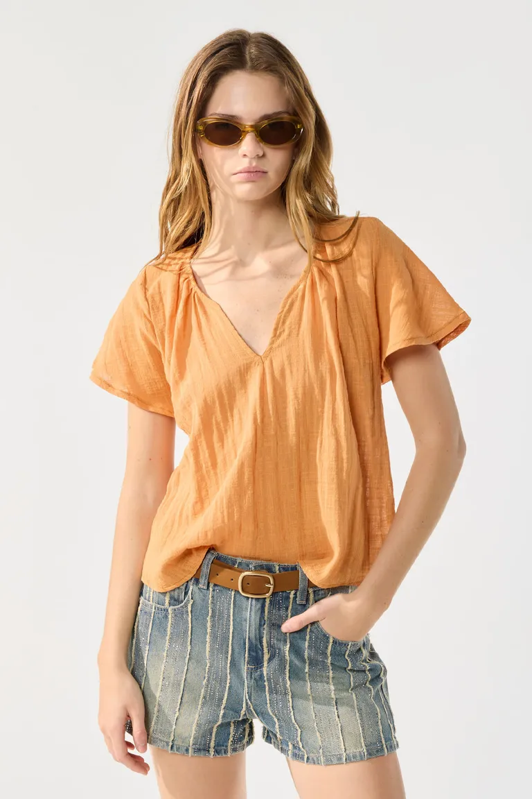 Blusa naranja con escote redondo y detalles de fruncidos, prenda versátil y elegante de Cuesta Blanca en Blusas para argentina