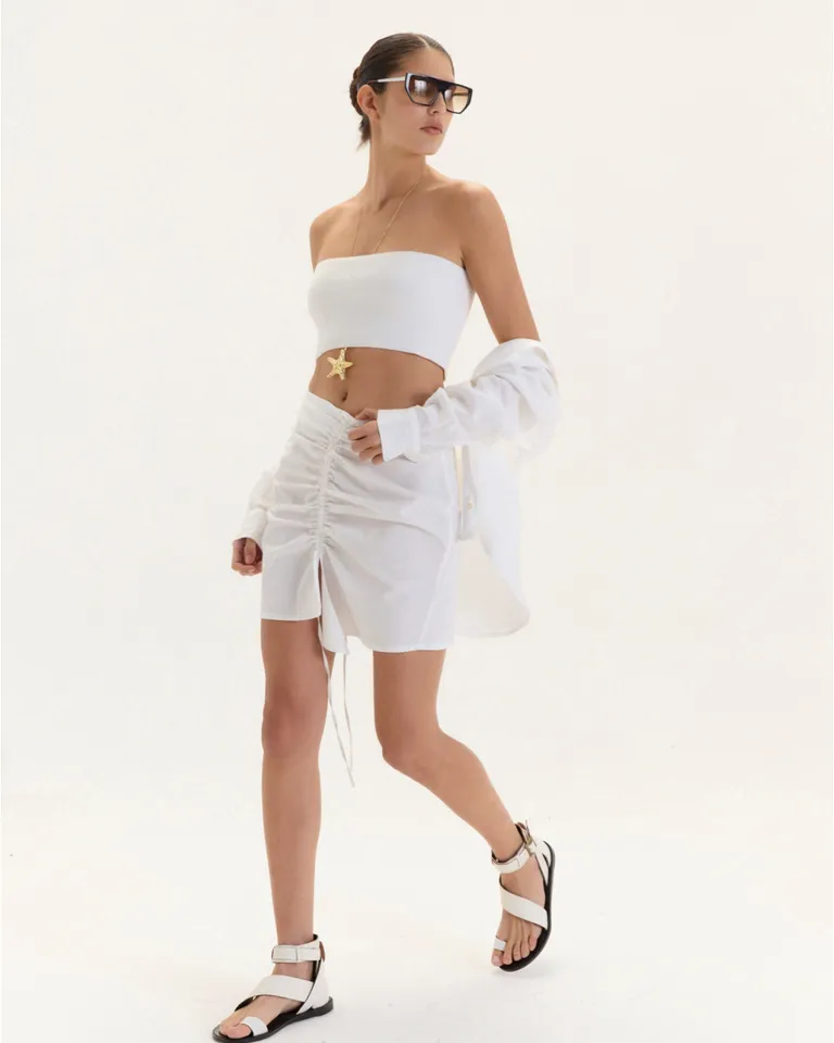 Falda Lucía: una prenda blanca corta y femenina con diseño fruncido y tajo central de Blue Sheep en Faldas para argentina