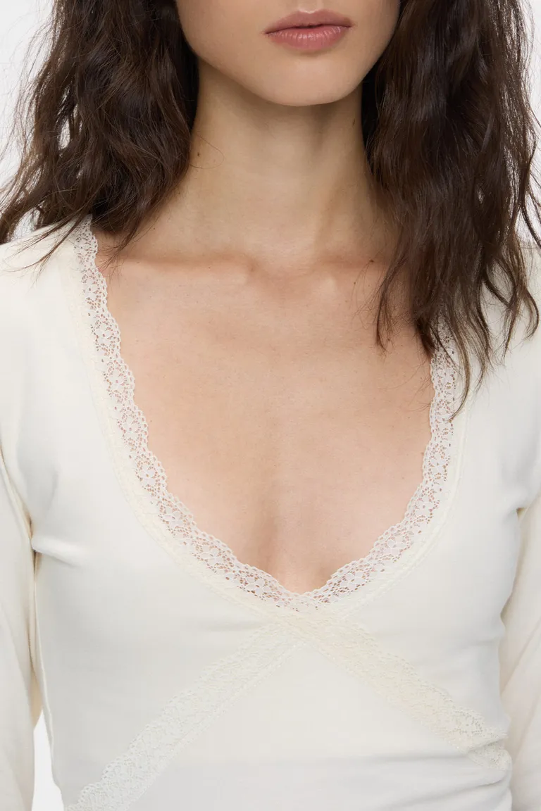 Remera de mangas largas entallada con escote en V y detalle de puntilla de Cuesta Blanca en Remeras para argentina