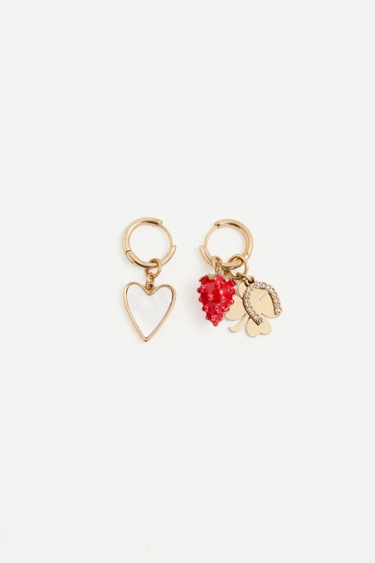 Aretes dorados con charms de trébol, herradura y frutilla en tono metálico de Rapsodia en Bijouterie para argentina