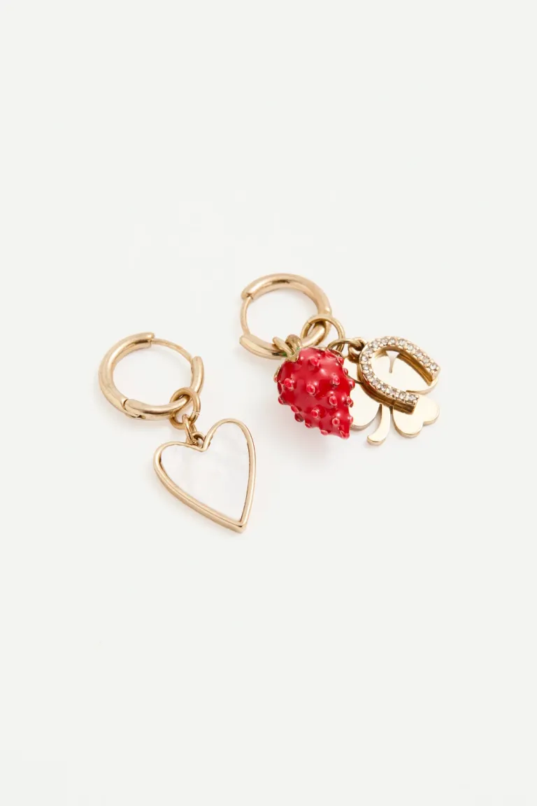 Aretes dorados con charms de trébol, herradura y frutilla en tono metálico de Rapsodia en Bijouterie para argentina