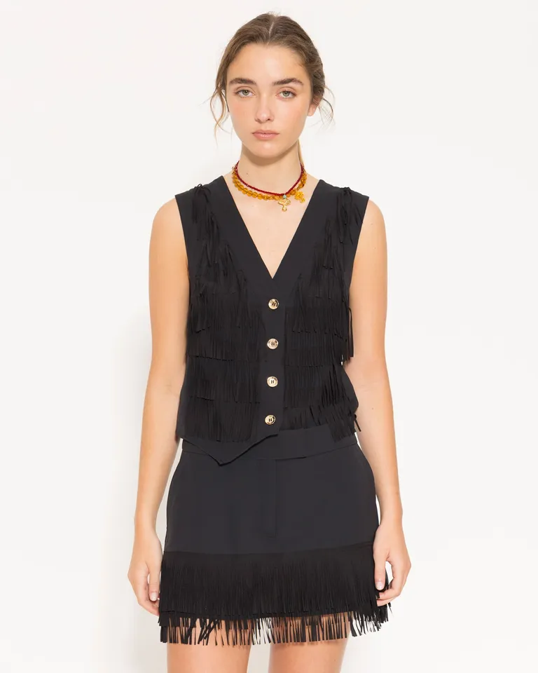 Vestido corto negro con flecos en la falda, escote en V y silueta ceñida de Jazmin Chebar en Vestidos para argentina