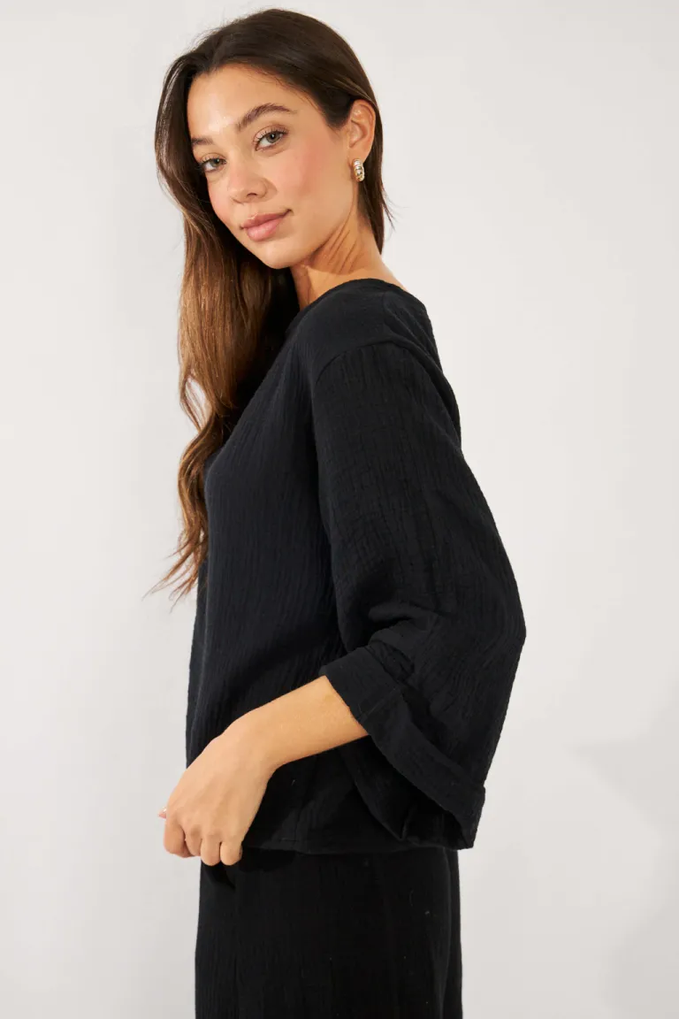 Blusa negra de manga 3/4 con puño atraque, ideal para looks formales y casuales de Belle en Blusas para argentina