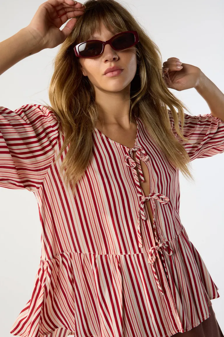 Blusa de diseño rayado con escote en V y detalles de lazos en el centro de Cuesta Blanca en Blusas para argentina