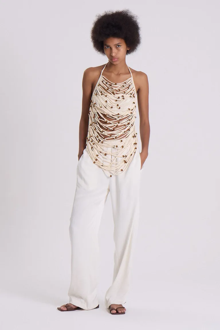 Top de tiras entrelazadas con cuentas en contraste, diseño halter y efecto de movimiento de Maria Cher en Tops para argentina