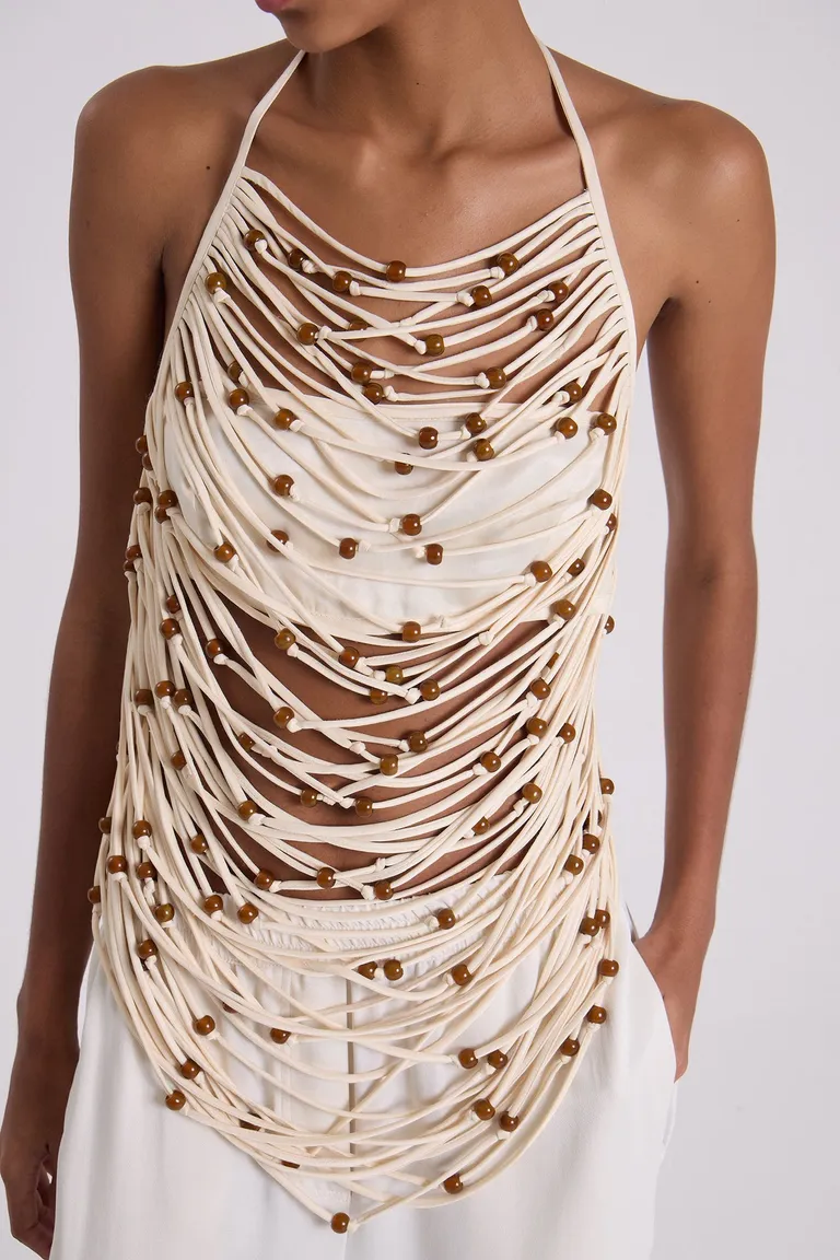 Top de tiras entrelazadas con cuentas en contraste, diseño halter y efecto de movimiento de Maria Cher en Tops para argentina