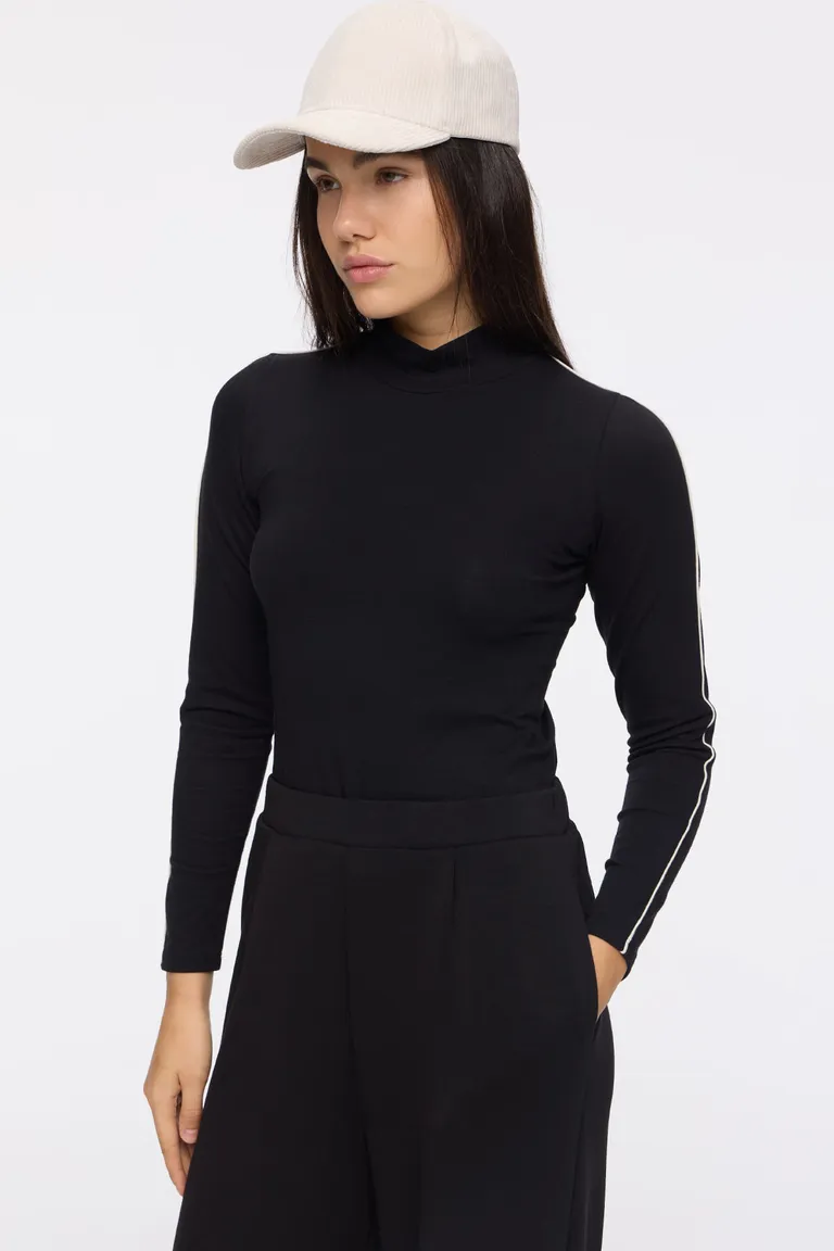 Remera al cuerpo de manga larga con cuello alto y detalles de vivo a contratono de Cuesta Blanca en Remeras para argentina