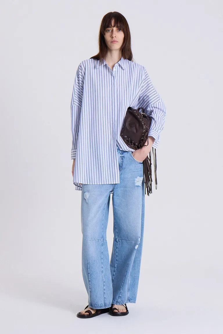 Camisa oversize de rayas blancas y azules, con detalle de logo bordado en el puño de Maria Cher en Camisas para argentina