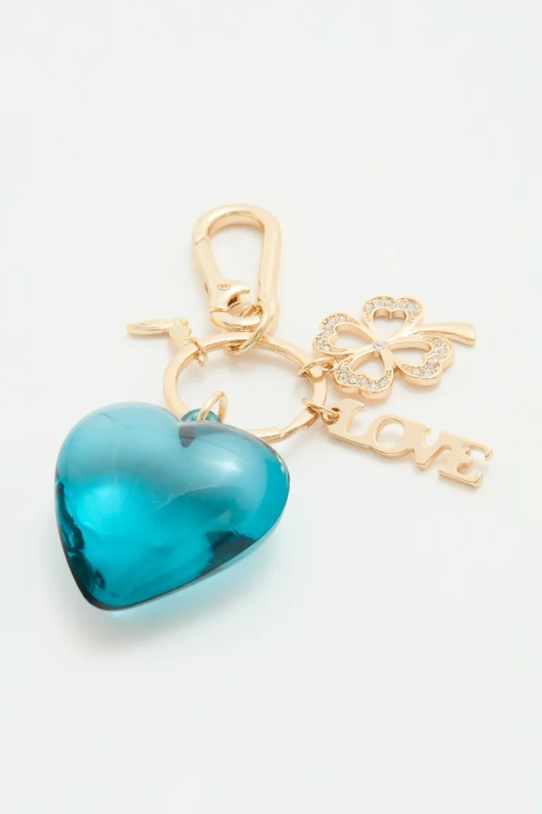 Llavero metálico con corazón y dijes decorativos de trébol y alas de Rapsodia en Llaveros para argentina