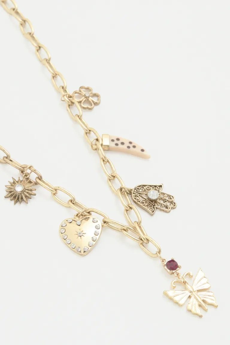 Collar dorado con dijes metálicos y strass, ideal para complementar tu estilo de Rapsodia en Bijouterie para argentina