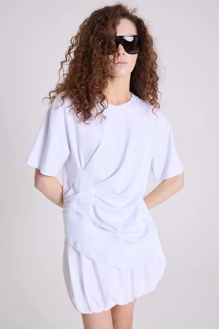 Remera blanca de corte amplio y pliegues sutiles, un básico elegante y versátil de Maria Cher en Remeras para argentina