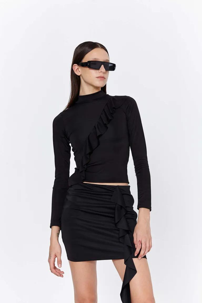 Elegante falda negra con volado lateral, diseño modular y moderno de Naíma en Faldas para argentina