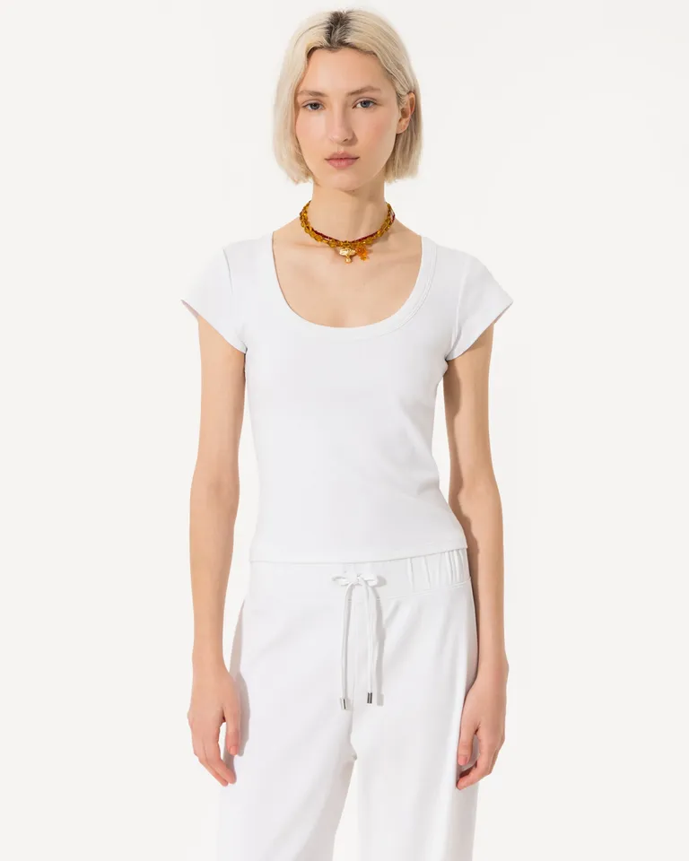 Remera blanca de corte ceñido, confeccionada en algodón elástico y con detalle de logo bordado de Jazmin Chebar en Remeras para argentina