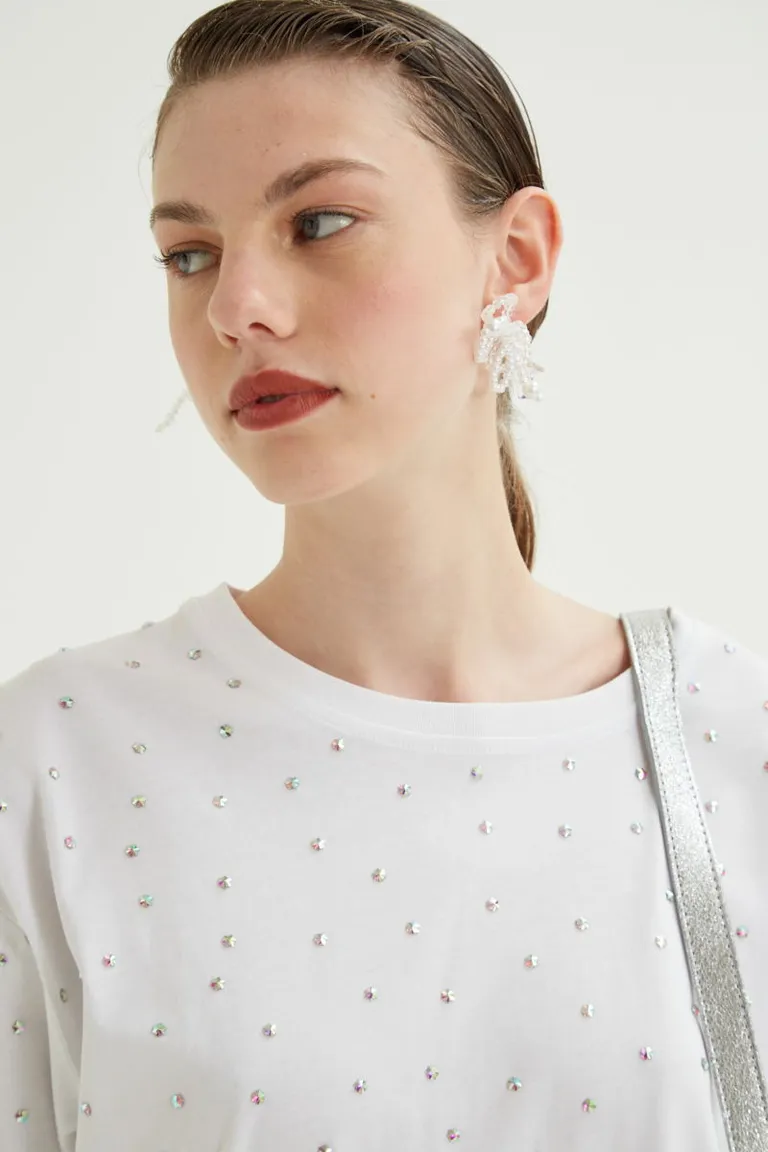 Remera de calce holgado con cuello redondo mangas cortas y detalle de aplicaciones brillantes distribuidas de Las Pepas en Remeras para argentina