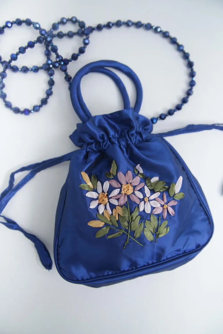 Cartera de tela satinada con bordado floral y correa de piedras facetadas en color azul de Las Pepas en Bolsos y Carteras para argentina