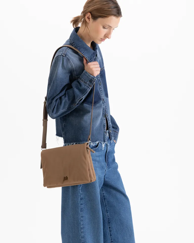 Cartera bandolera rectangular con correa regulable y cierre, presentando aplique metálico distintivo en la parte frontal de Jazmin Chebar en Bolsos y Carteras para argentina