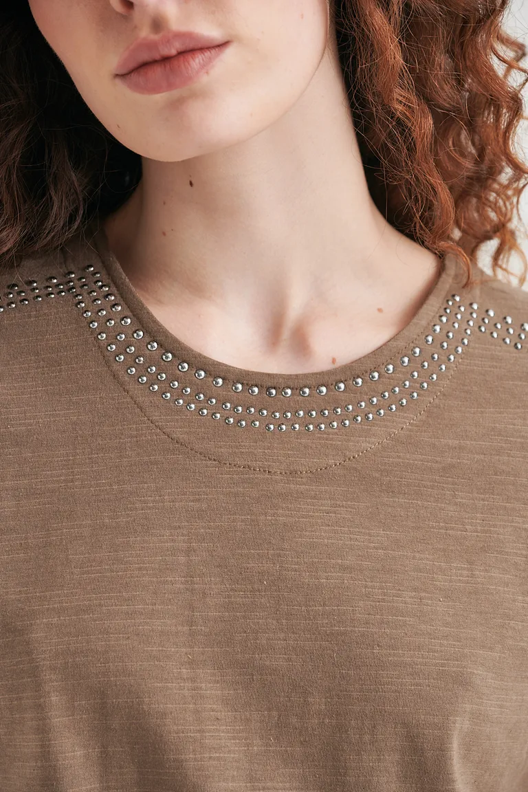 Remera informal con acentos metálicos en el cuello, un básico versátil para el armario femenino de Sweet en Remeras para argentina