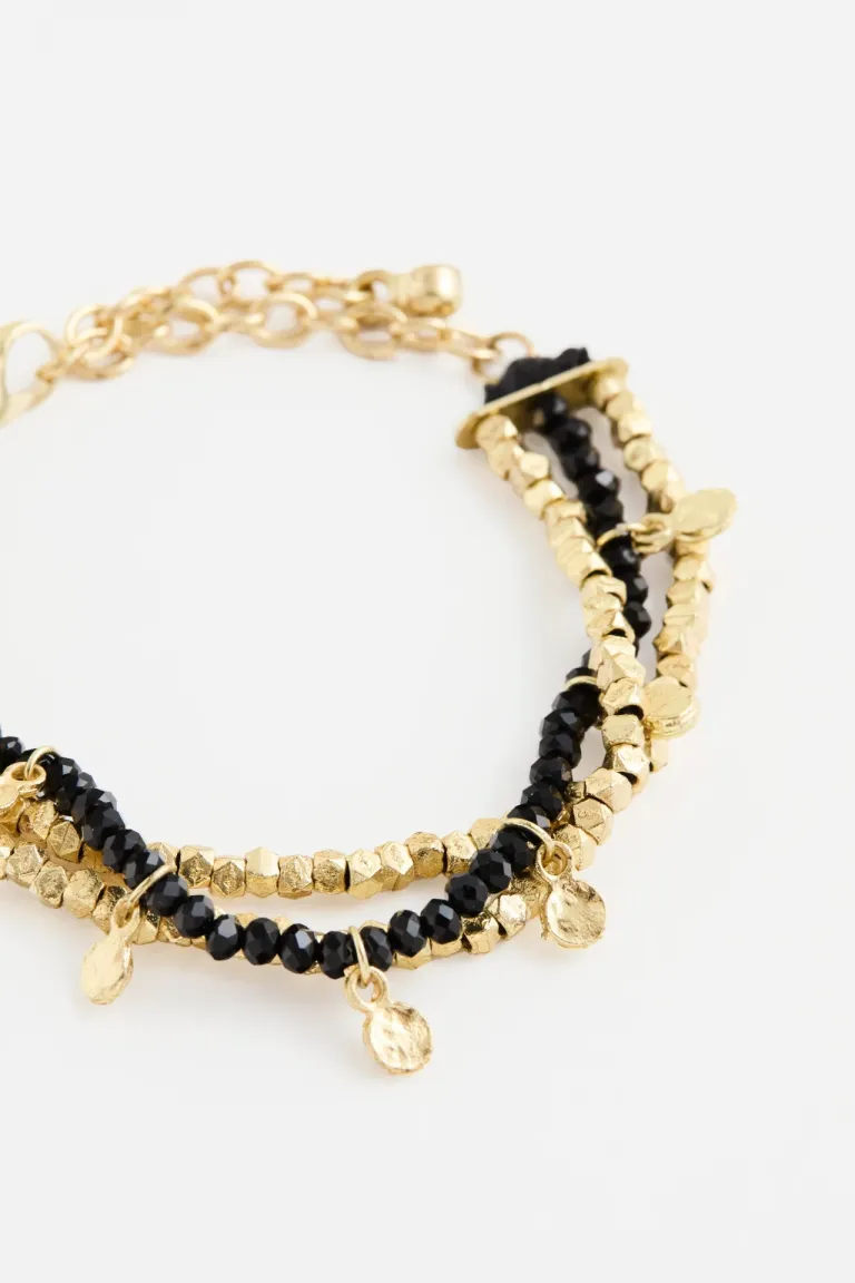 Pulsera de diseño multihilera con cuentas facetadas y dijes metálicos colgantes con cierre ajustable de Rapsodia en Bijouterie para argentina