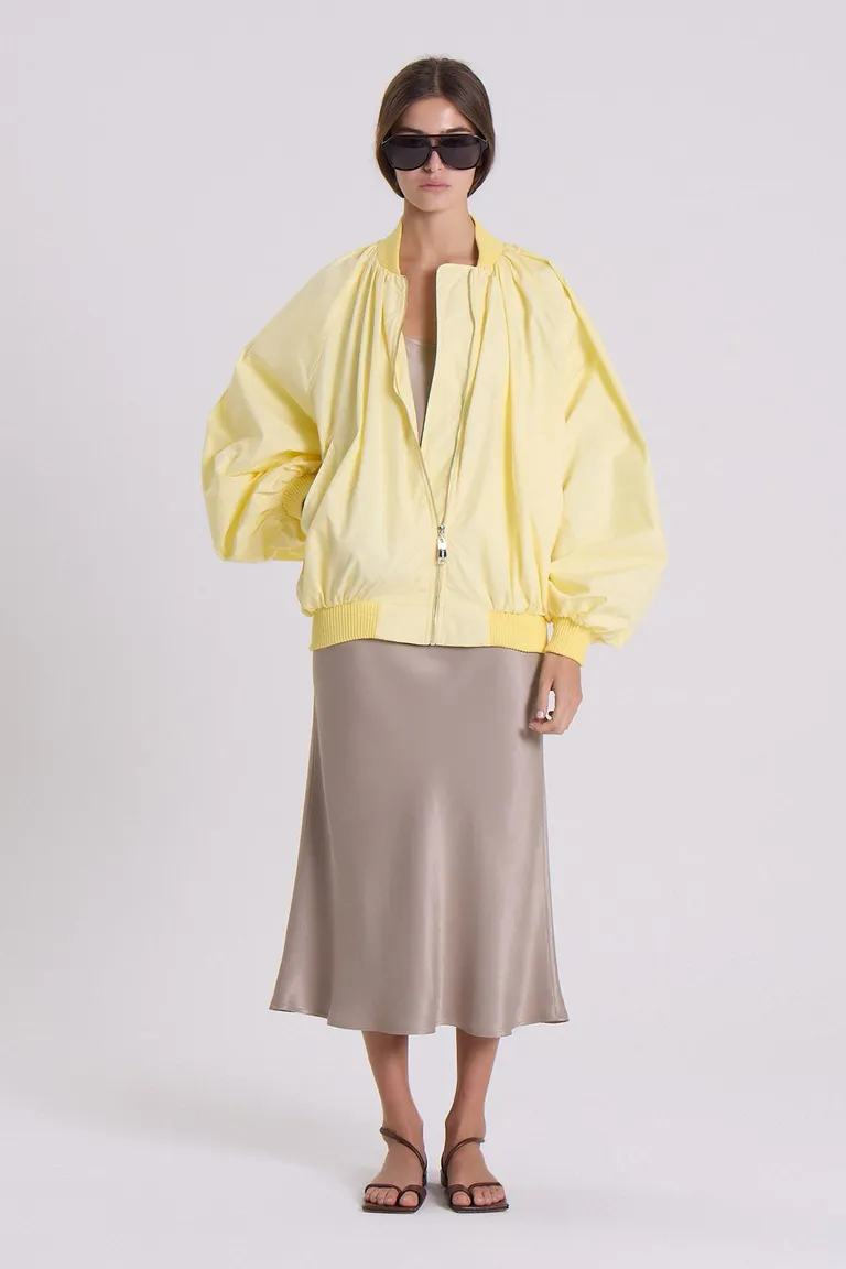 Campera bomber amarilla de gabardina liviana con silueta envolvente y detalles funcionales de Maria Cher en Chaquetas para argentina
