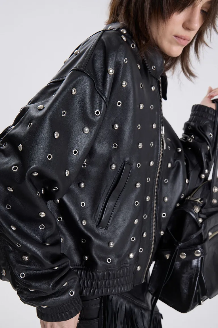 Campera bomber con cierre frontal, cuello clásico y detalles de apliques metálicos distribuidos en toda la prenda de Maria Cher en Chaquetas para argentina