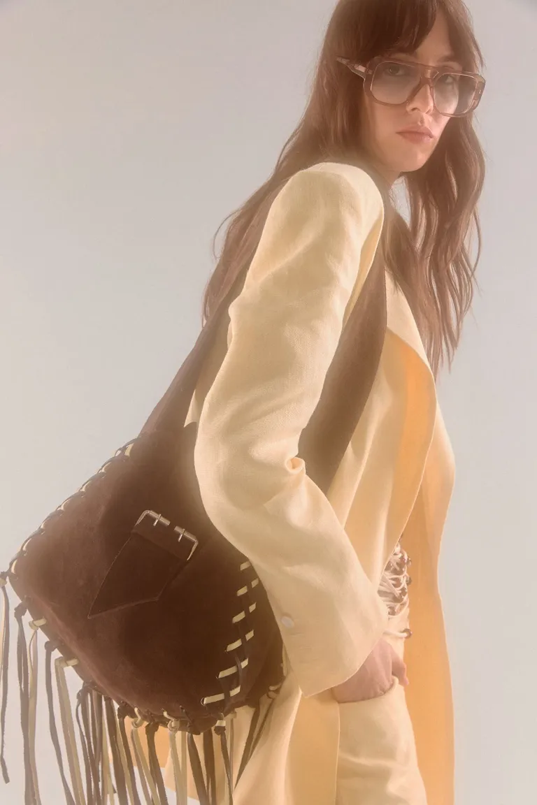 Bolso de gamuza marrón con detalles entrelazados y flecos, un accesorio versátil y de estilo atemporal de Maria Cher en Bolsos y Carteras para argentina