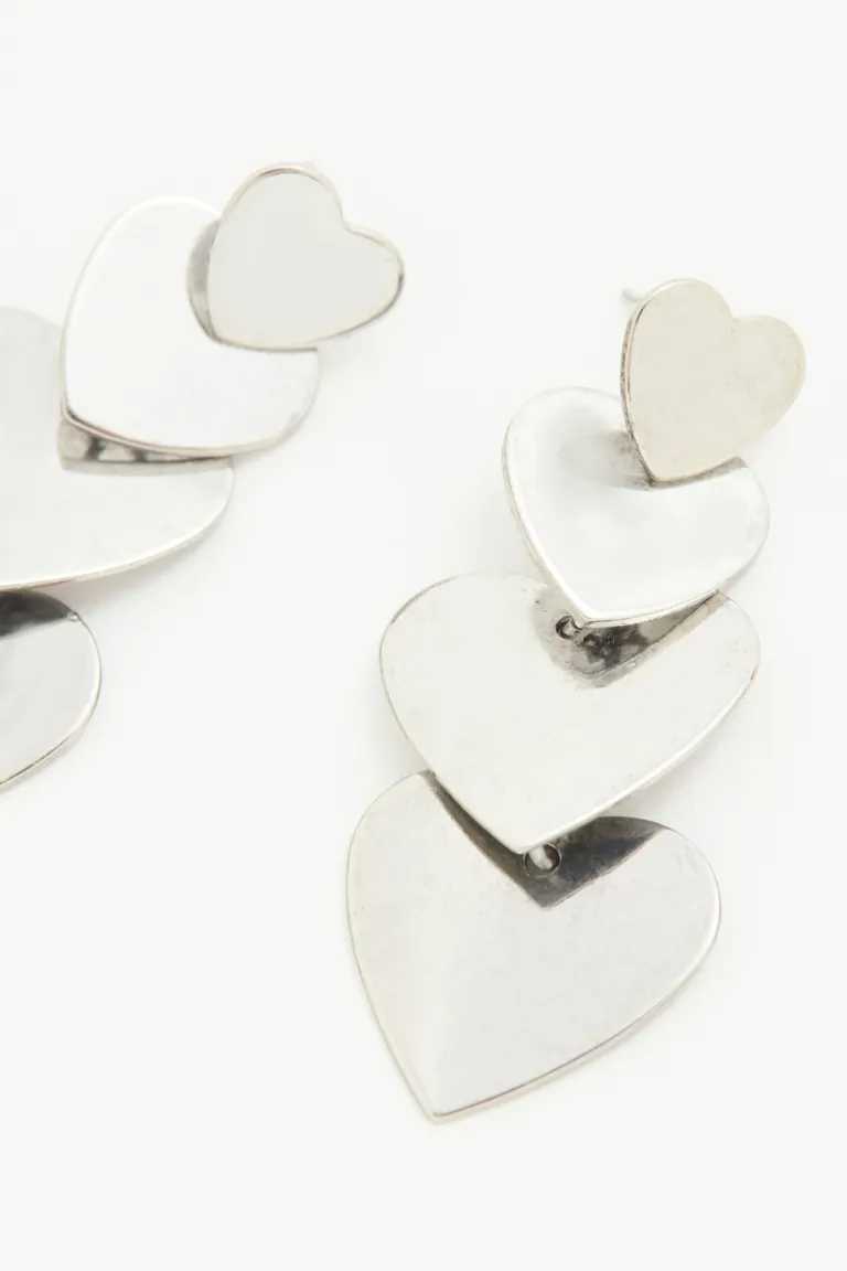 Aros largos de corazones en distintos tamaños, color plateado, pasantes de Rapsodia en Bijouterie para argentina