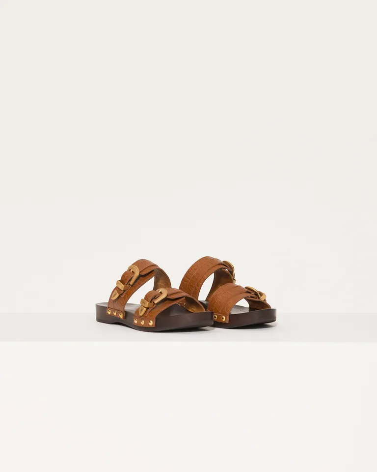 Sandalias de zuecos planos de cuero con detalles metálicos y base de madera de Jazmin Chebar en Zuecos Planos para argentina