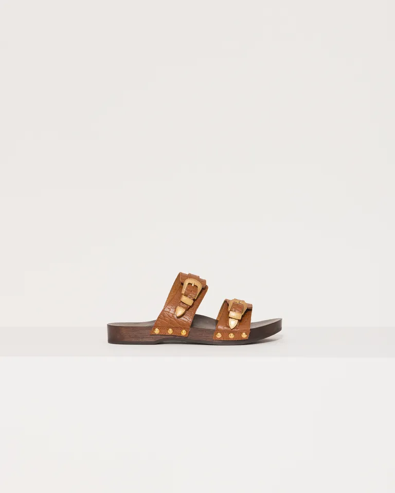 Sandalias de zuecos planos de cuero con detalles metálicos y base de madera de Jazmin Chebar en Zuecos Planos para argentina
