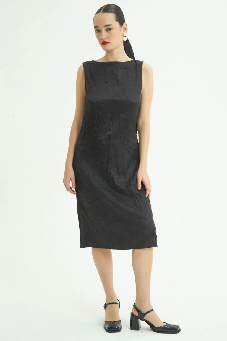 Vestido negro midi de satén con textura arrugada y detalles de abertura en la espalda de Las Pepas en Vestidos para argentina
