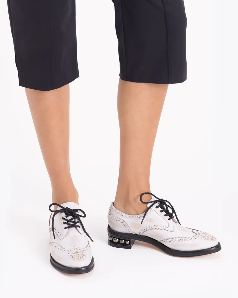 Zapato acordonado con diseño de picado y detalle de tachas en el taco de Jazmin Chebar en Abotinados para argentina