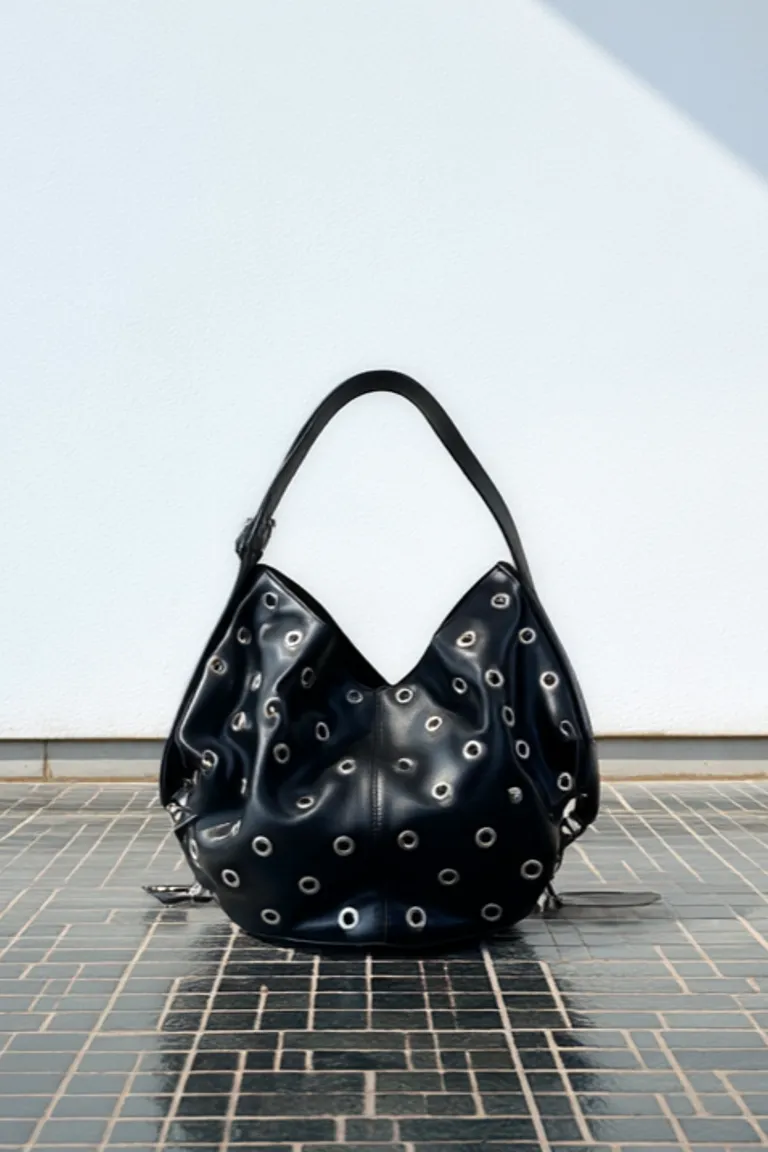 Cartera de cuero negro con detalles de remaches, de silueta fluida y manija amplia de Maria Cher en Bolsos y Carteras para argentina