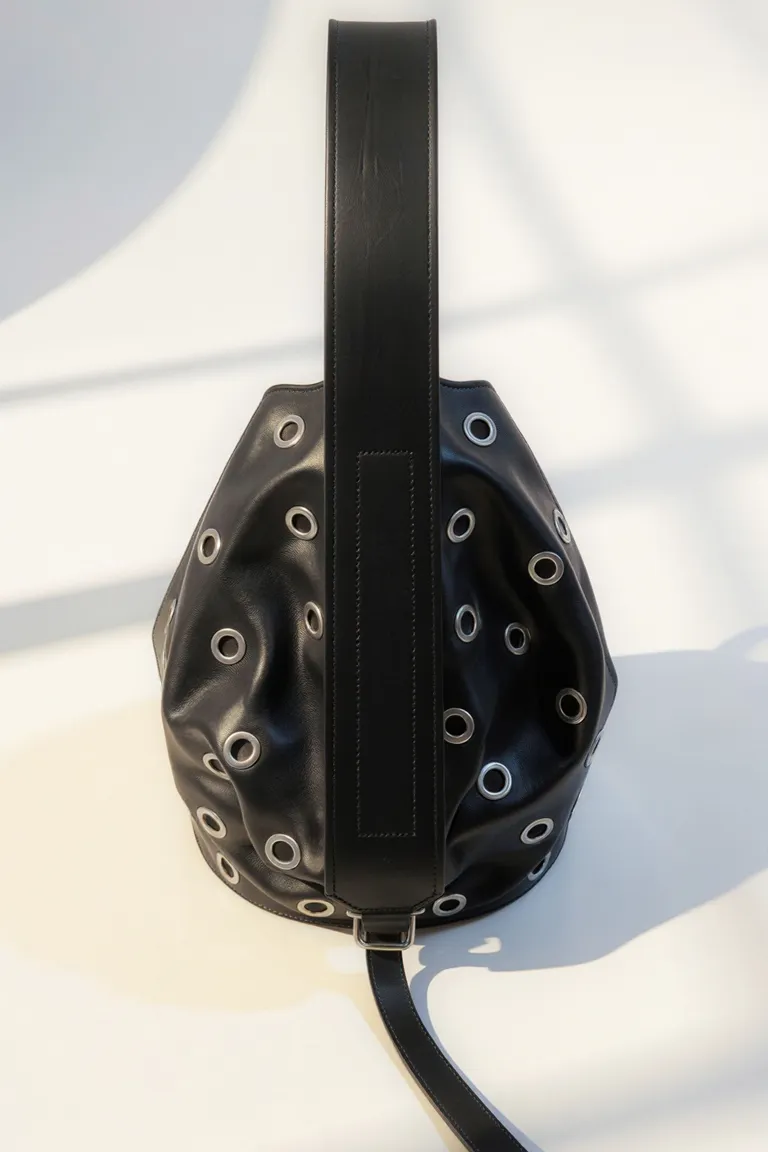 Cartera de cuero negro con detalles de remaches, de silueta fluida y manija amplia de Maria Cher en Bolsos y Carteras para argentina