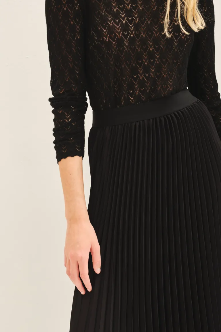 Falda midi plisada en color negro, una prenda elegante y versátil para todo tipo de ocasiones de Rapsodia en Faldas para argentina