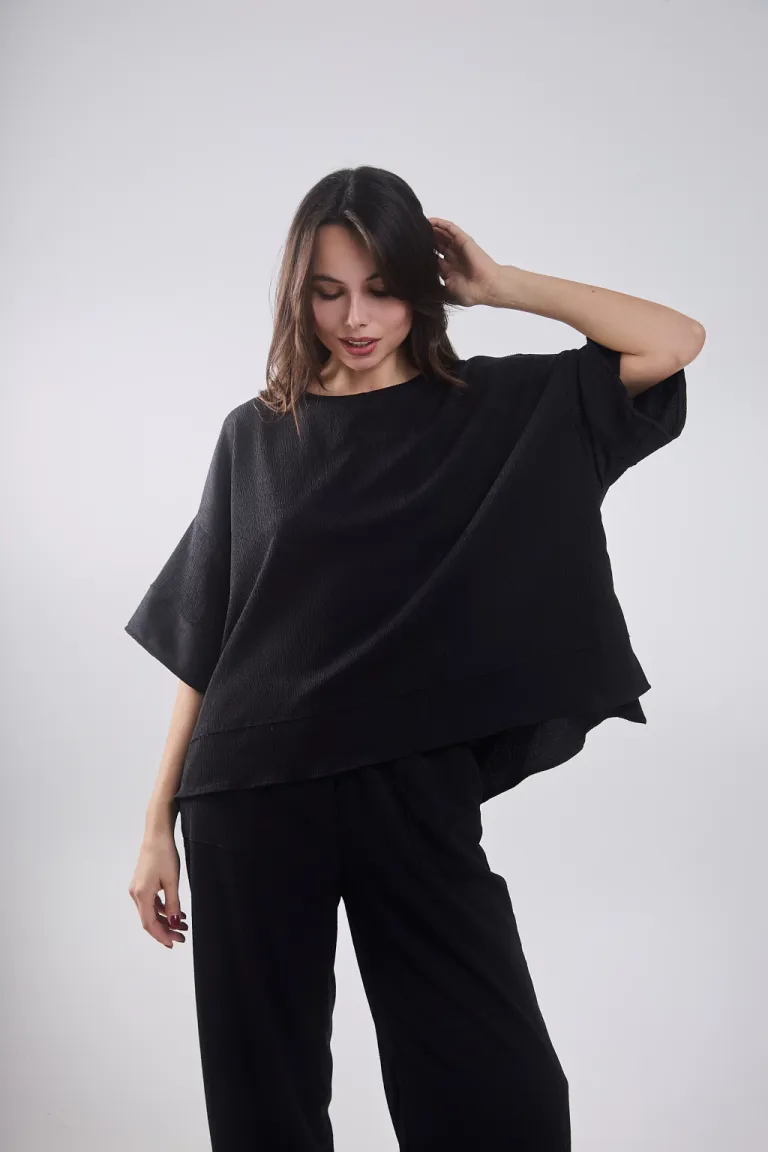 Remera negra con recortes y tajo lateral, ideal para lookear con pantalón carmelo de Belle en Remeras para argentina