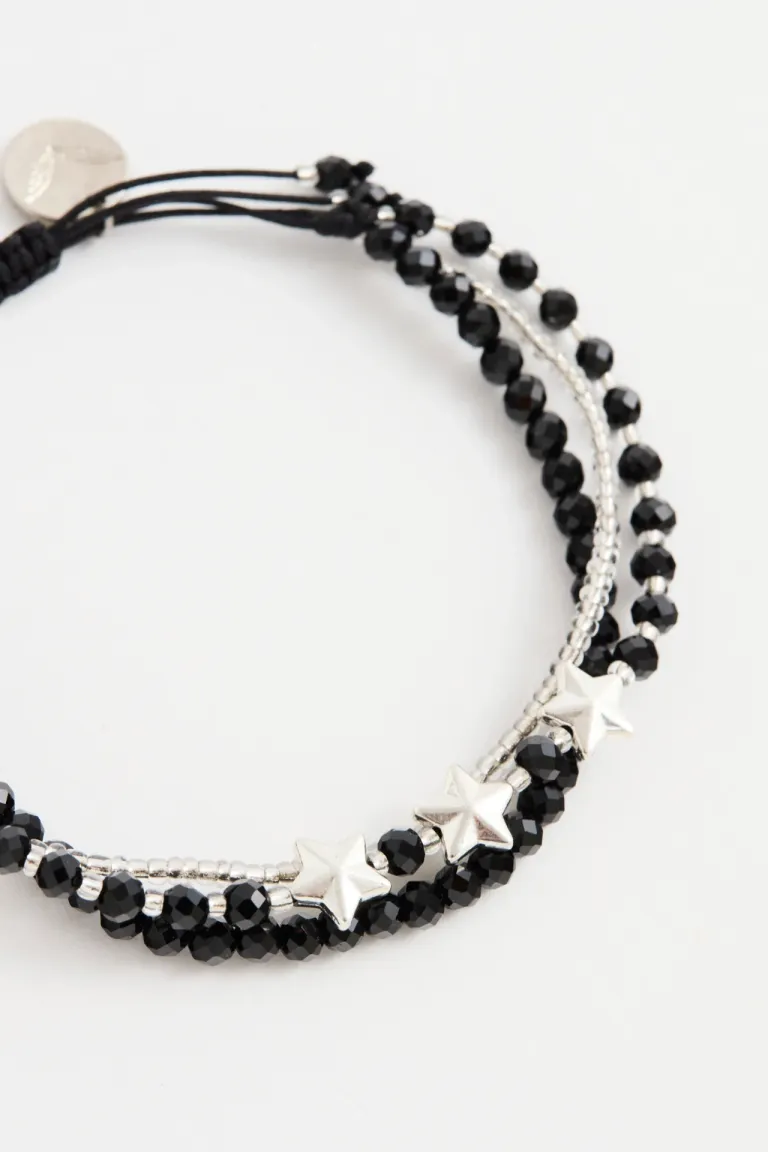 Pulsera ajustable de varias vueltas con dijes de estrellas metálicas y esferas facetadas de Rapsodia en Bijouterie para argentina