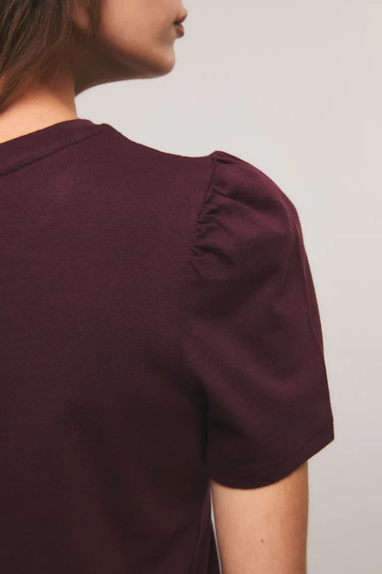 Remera manga corta con escote redondo y detalles fruncidos en hombros junto a estampado frontal de Kosiuko en Remeras para argentina