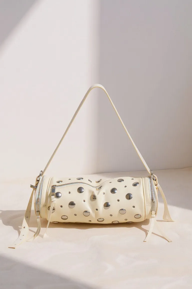 Cartera cilíndrica de cuero con remaches y cierre de Maria Cher en Bolsos y Carteras para argentina