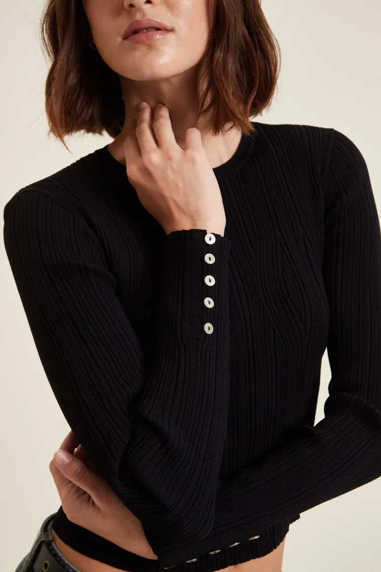 Sweater tejido escote redondo de calce entallado con detalle de botones en los puños de Cuesta Blanca en Buzos y Sweaters para argentina