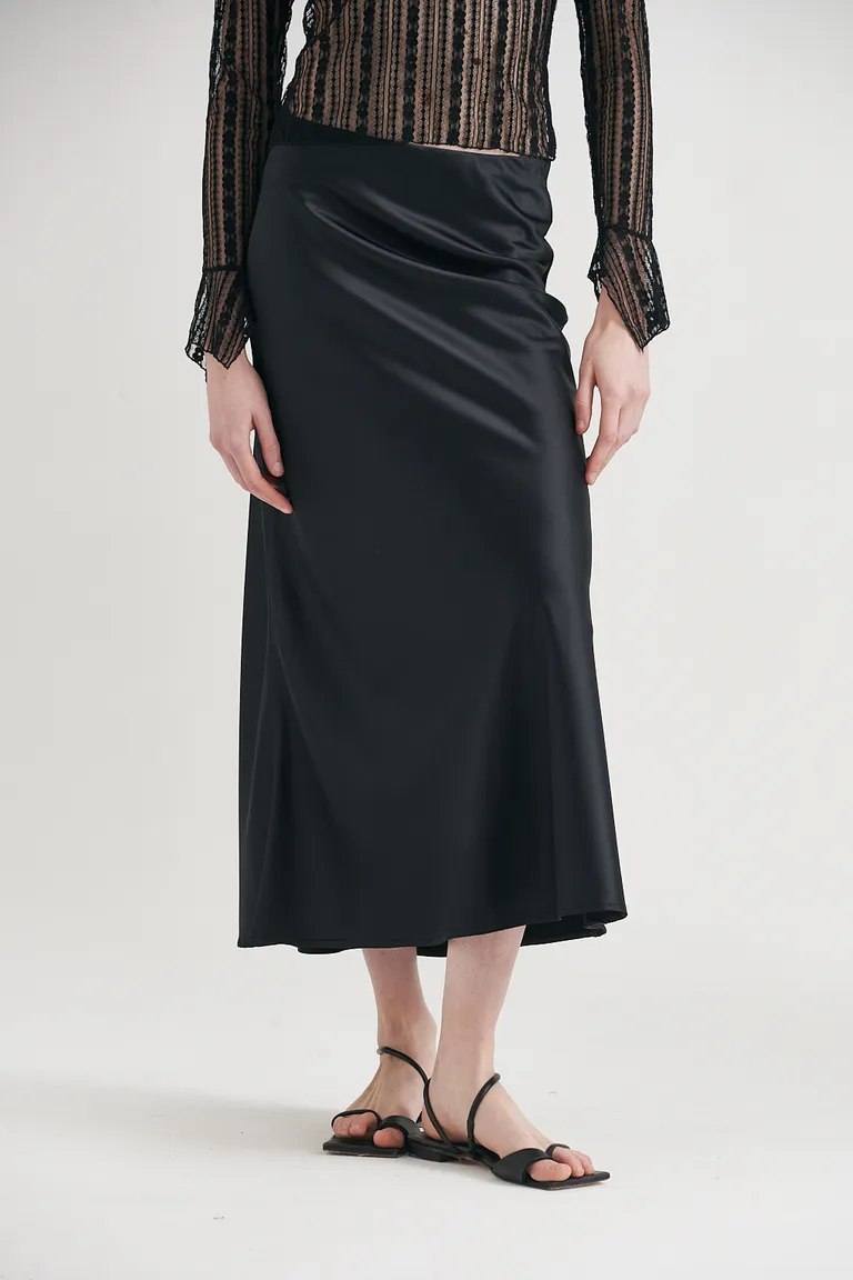Falda midi de satén negra con caída fluida y silueta elegante de Sweet en Faldas para argentina