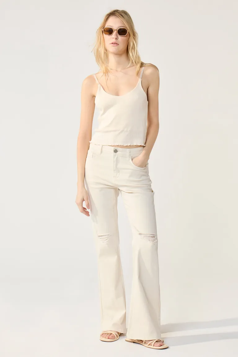 Pantalón jean tiro medio con roturas en rodillas y corte flare acampanado de Cuesta Blanca en Pantalones para argentina