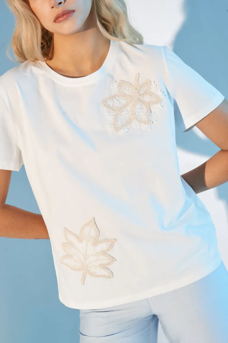 Remera blanca con bordados de flores, un diseño elegante y femenino de Apricot en Remeras para argentina