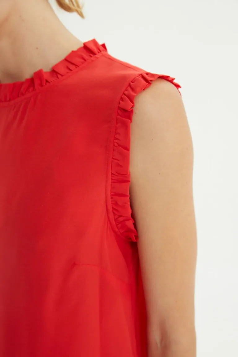 Top sin mangas con volados en cuello y sisas, corte recto y cierre de botones posterior de Las Pepas en Tops para argentina