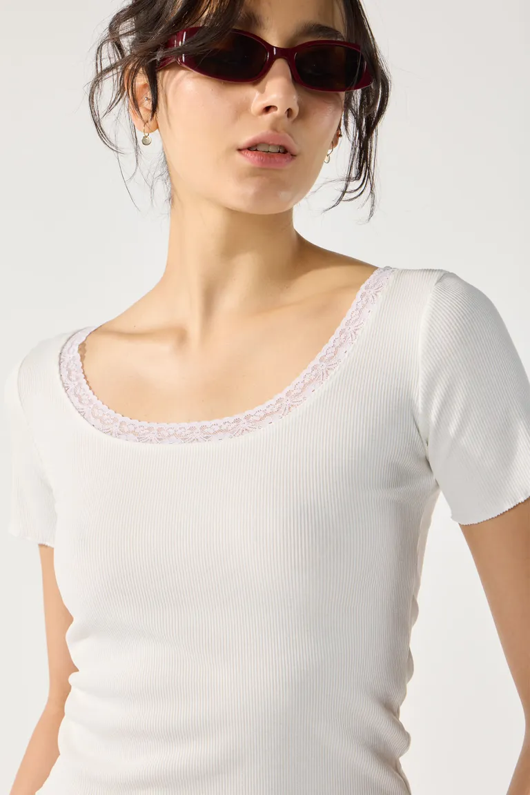 Remera blanca de algodón con encaje en el escote, de manga corta y diseño sencillo de Cuesta Blanca en Remeras para argentina