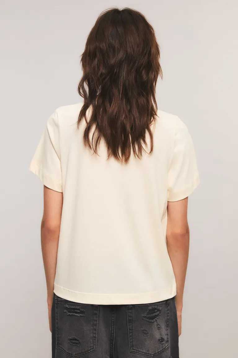 Remera de calce regular con cuello redondo, mangas cortas e inscripción frontal con detalle bordado de lunares de Kosiuko en Remeras para argentina