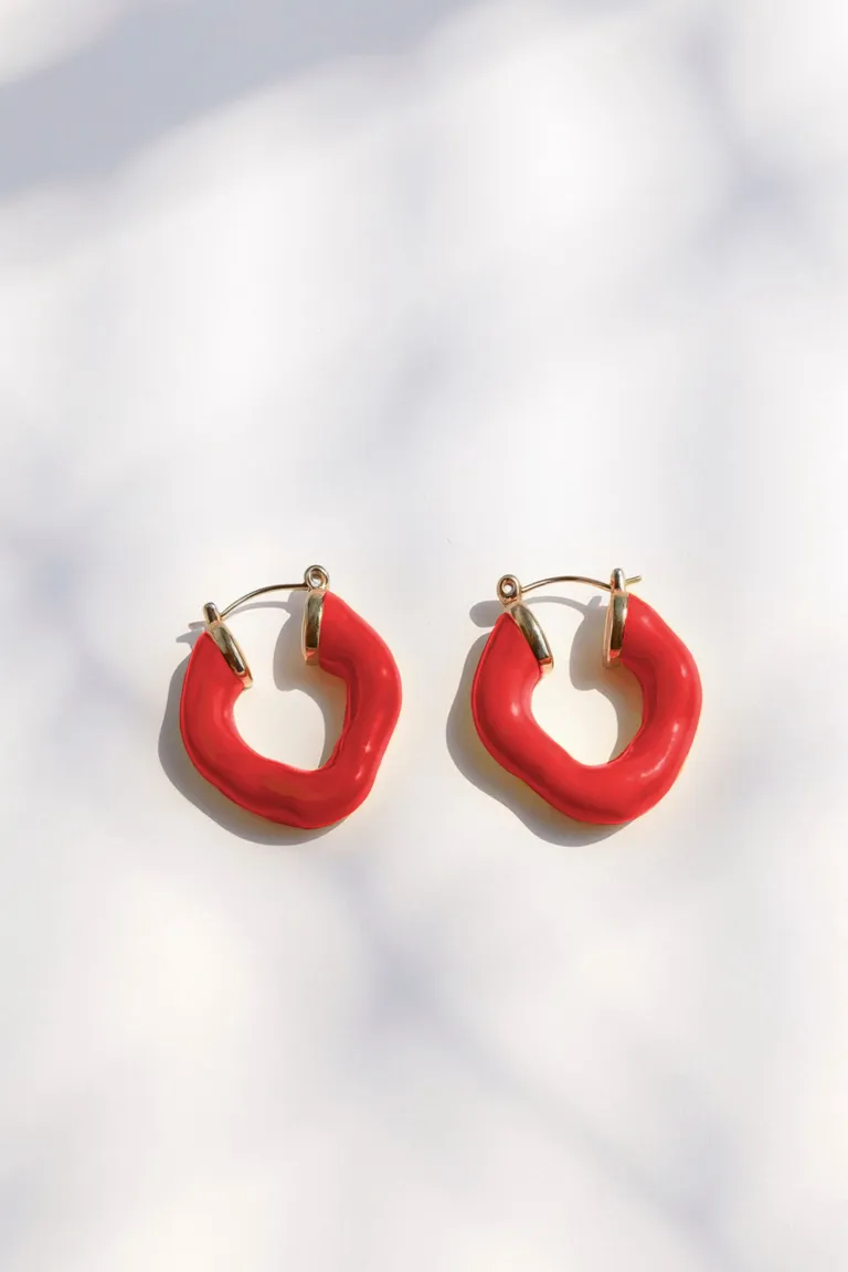 Aros rojos brillantes de diseño orgánico y textura lisa de Maria Cher en Bijouterie para argentina