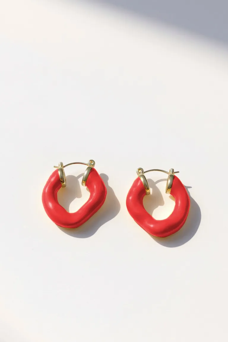 Aros rojos brillantes de diseño orgánico y textura lisa de Maria Cher en Bijouterie para argentina