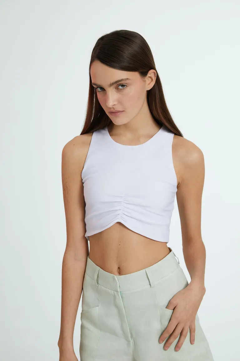 Top sin mangas de corte musculosa en color blanco, con detalle de fruncido en el centro de Naíma en Tops para argentina