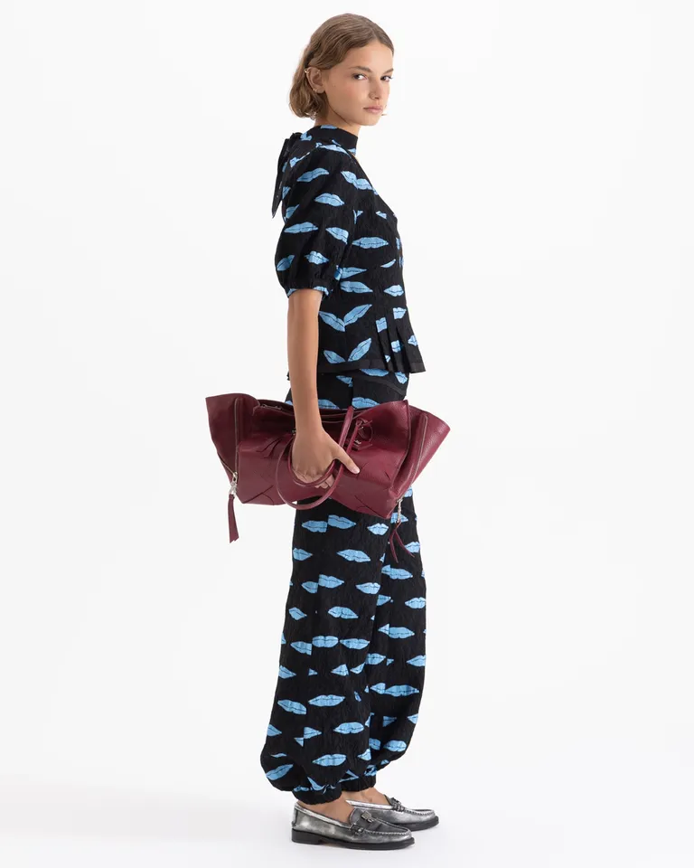 Top con cuello lazo, mangas abullonadas y diseño gráfico con recortes en el delantero y volado inferior de Jazmin Chebar en Tops para argentina